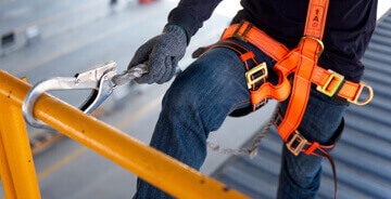 Worker in an orange safety harness
