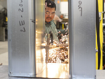 Close up view of a Heritage worker in their sheet metal and piping fabrication facility